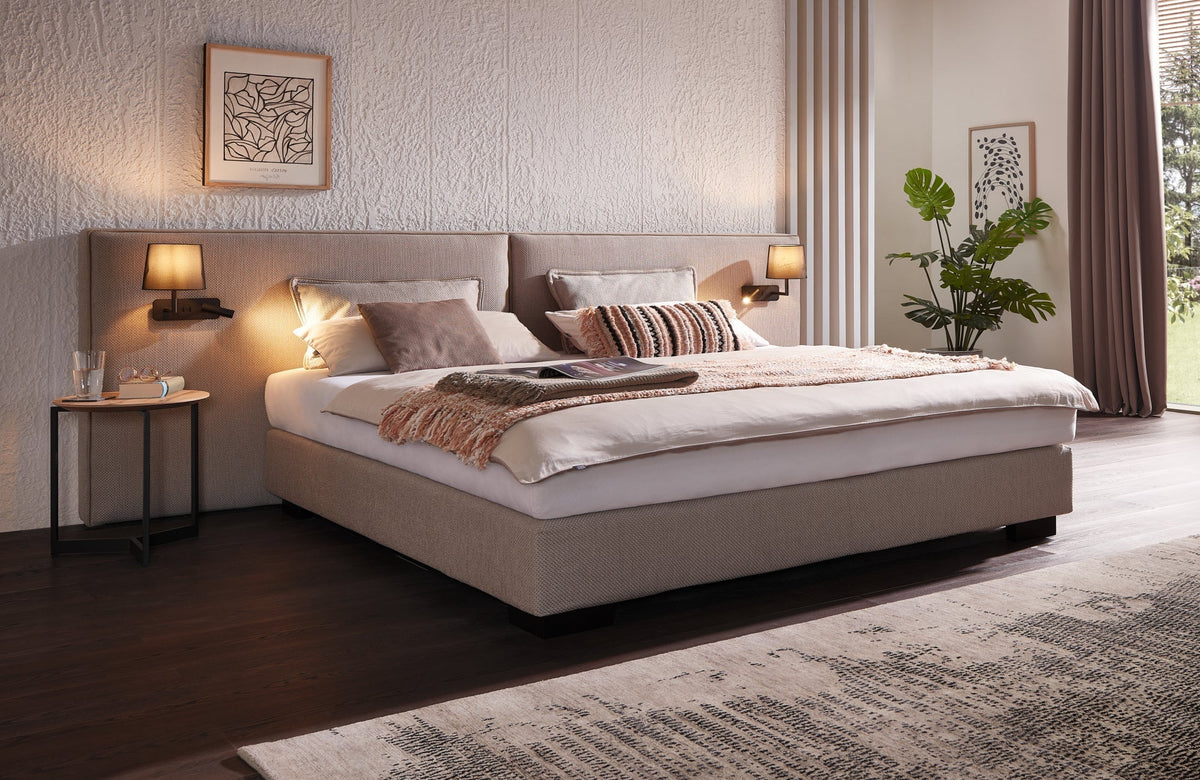 SWISSpur Boxspringbett mit gepolstertem Kopfteil in einem hellen Schlafzimmer